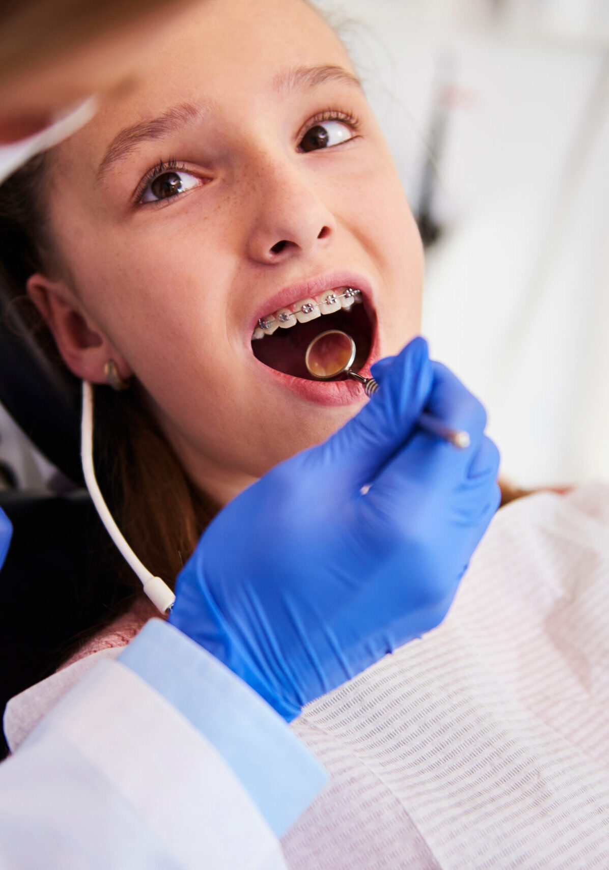 Part of orthodontist examining child's teeth in dentist's office